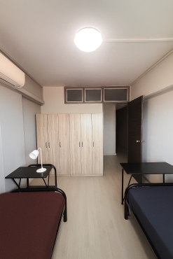 Common room with wall mount aircon and stand fan